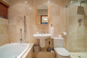 A modern bathroom with a bathtub, sink, toilet, and shower.