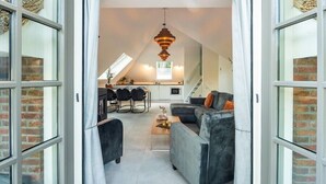 Un espace de vie moderne de style loft comprenant une cuisine, un coin repas et un escalier menant à un niveau supérieur.