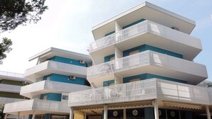 Un immeuble à plusieurs étages, doté de balcons et d’une entrée au niveau du sol.