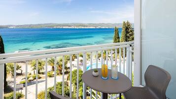 Un balcon avec vue sur la plage et la piscine.
