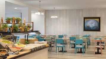 Zona de buffet amb diferents plats i un quadre a la paret.