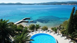 Um resort com piscina, praia e vista para o oceano.