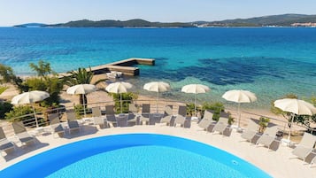 Una piscina al aire libre de temporada, sombrillas