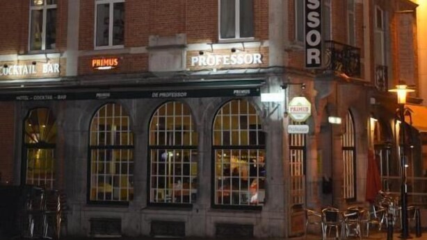 Een hotel genaamd "Hotel Professor" met een klassiek bakstenen gevel, gebogen ramen en een bordje dat een cocktailbar aangeeft.