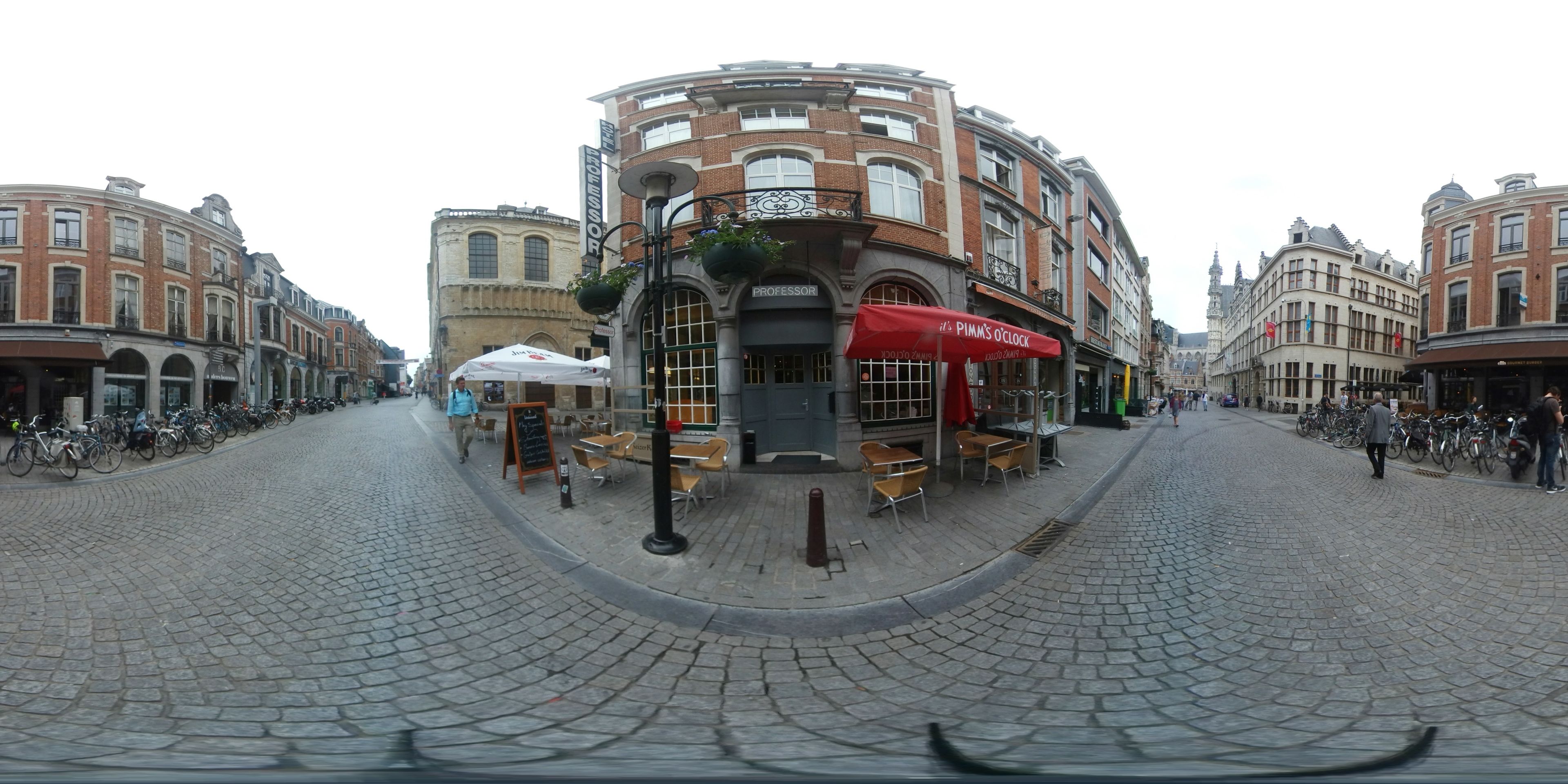Une rue pavée où se trouvent un café appelé « Pim’s O’Clock » et une librairie.