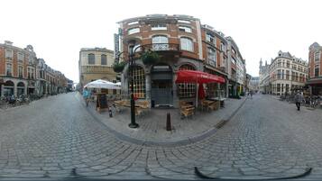 Une rue pavée où se trouvent un café appelé « Pim’s O’Clock » et une librairie.
