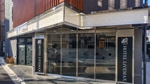 A hotel entrance with a modern design, featuring a glass facade and a metal frame structure. - HOTEL LiVEMAX Kyoto Nijojo-kita (Kyoto)