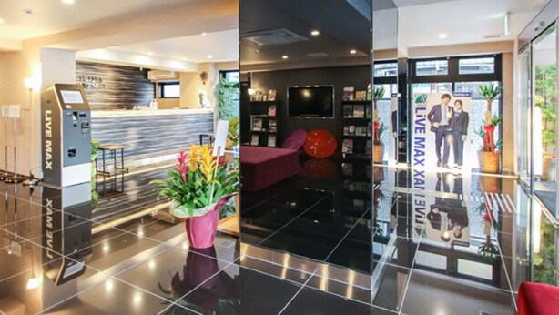 A modern hotel lobby with a reception desk, a seating area, and a glass entrance. - HOTEL LiVEMAX Kyoto Nijojo-kita (Kyoto)