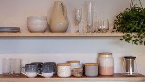 Two shelves with various ceramic and glassware, including cups, mugs, and vases. - Roker Street Retreat - Contemporary Kiwi Styled Studio (Christchurch)