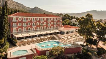 Un hôtel doté d’une piscine, d’un espace extérieur aménagé et offrant une vue sur les montagnes.