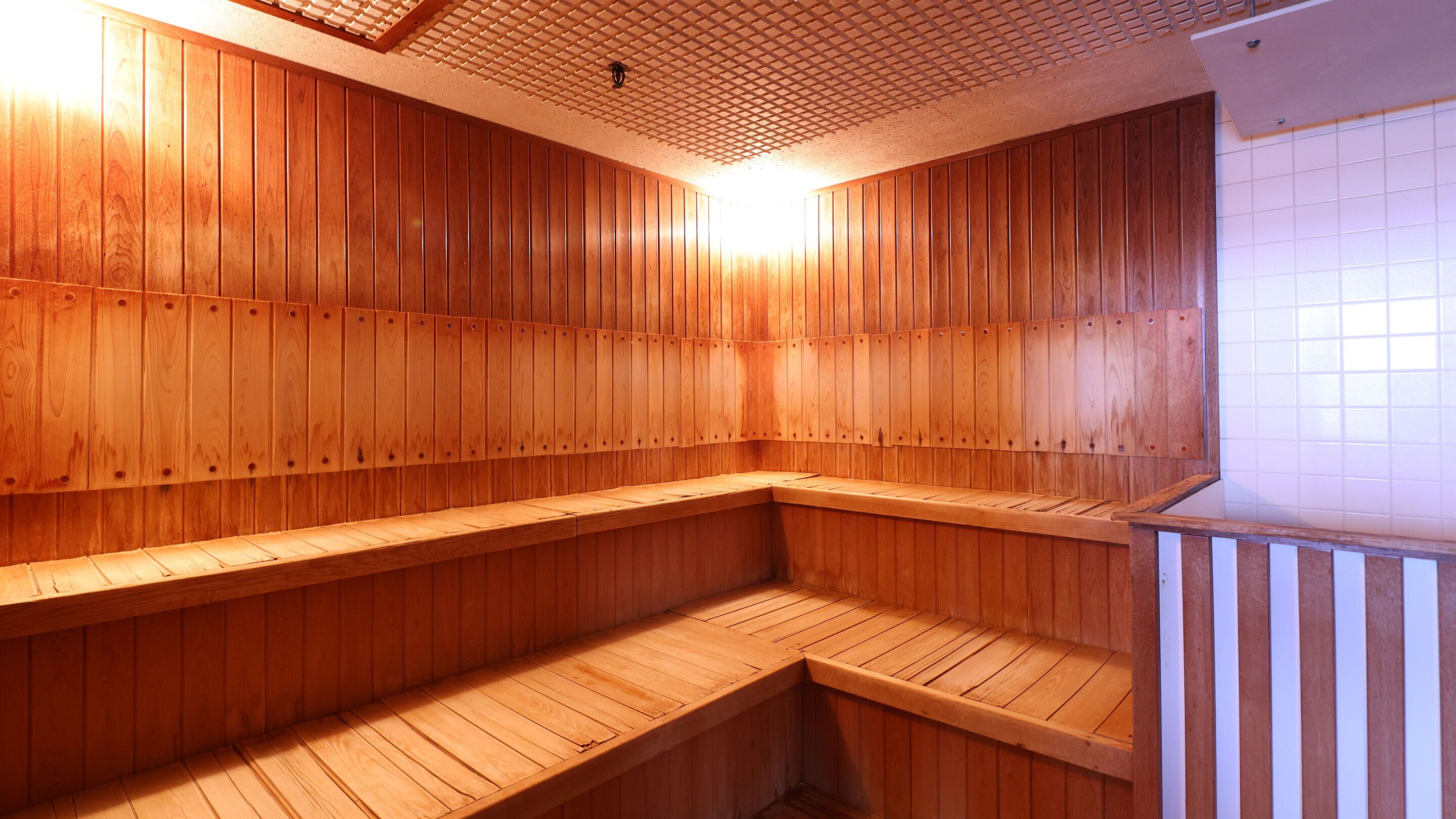 Sauna, jossa on puuseinät ja -lauteet.