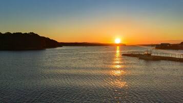 A sunset over a calm body of water with a dock and a pier.