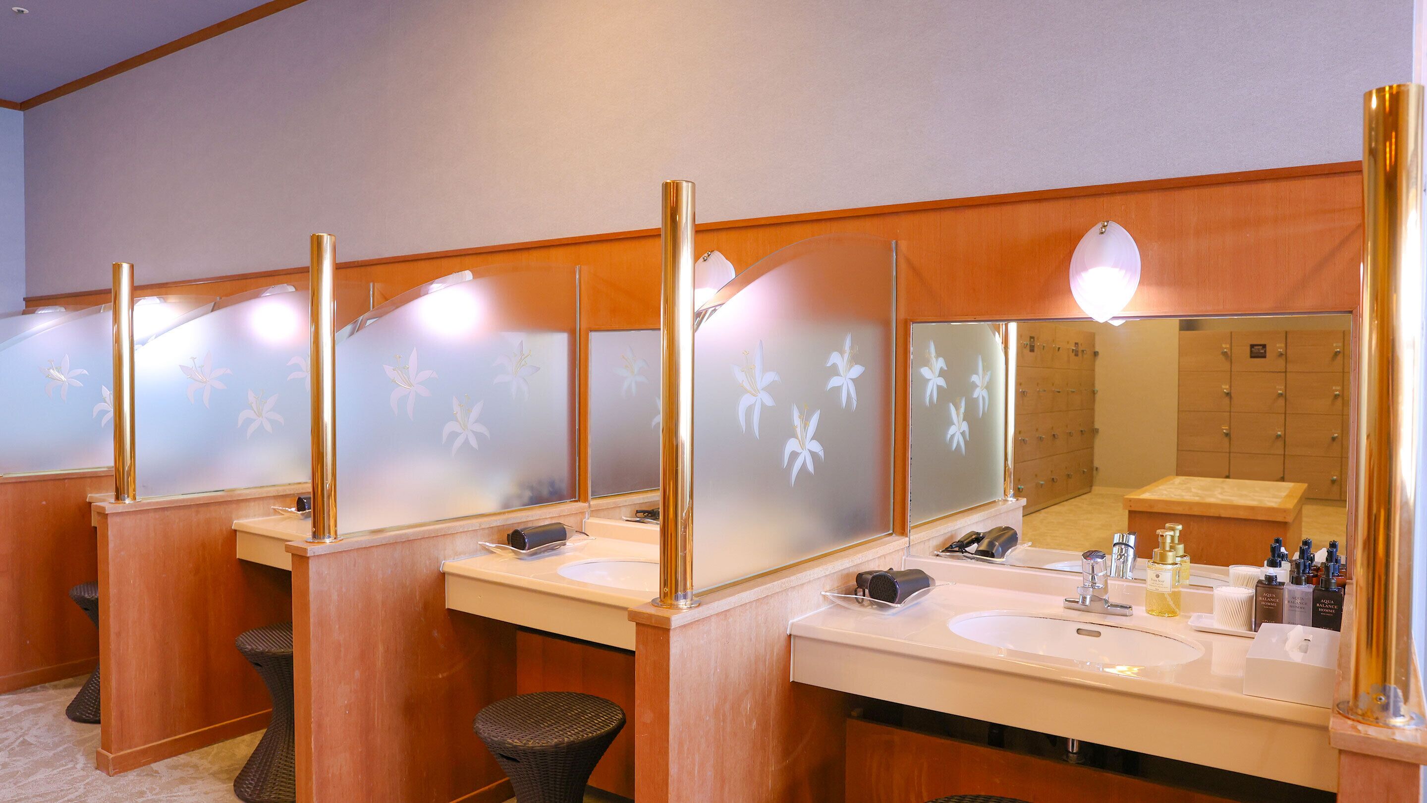 A hotel bathroom with multiple sinks, mirrors, and toiletries.