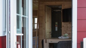 A wooden interior with a dining area, a door, and a window. - Ferienhof Schild (Wangerland)
