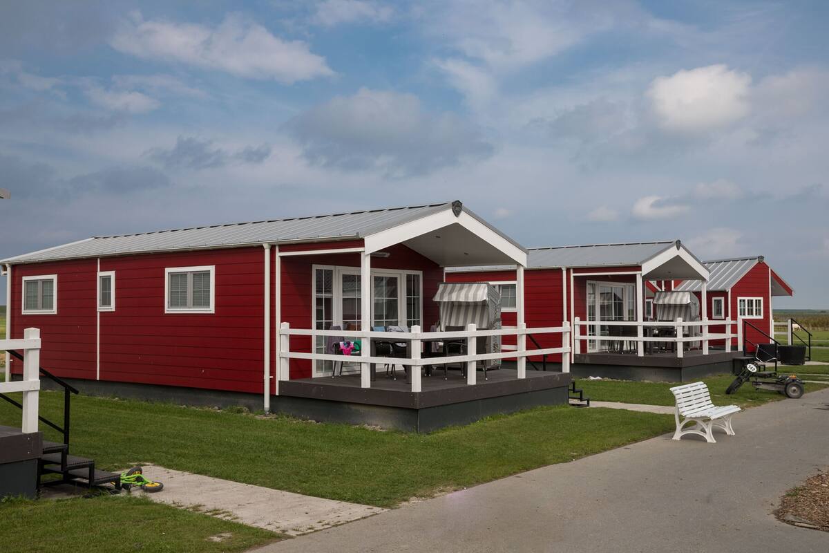 A red building with a porch and a covered patio area.