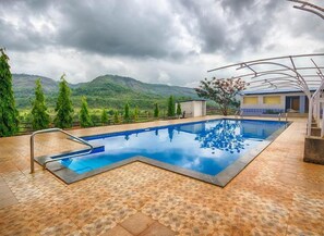 Una piscina con vistas a montañas y árboles.