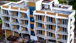 A multi-story building with balconies, a red roof, and a courtyard area. - Dreammland Resort (Shahapur)