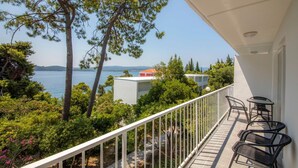 A balcony with a view of the sea, surrounded by greenery and a white railing. - Bellevue Maradiso Casa by Aminess (Orebic)
