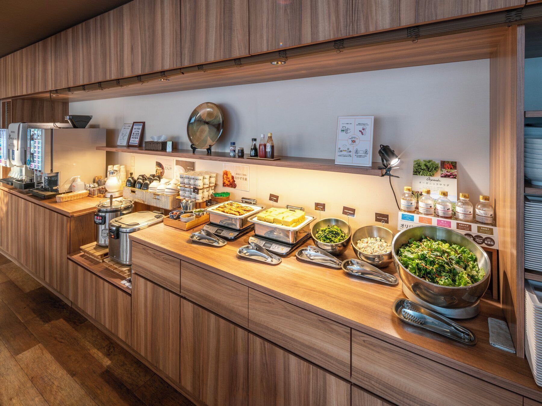 A buffet counter with various food items and condiments.