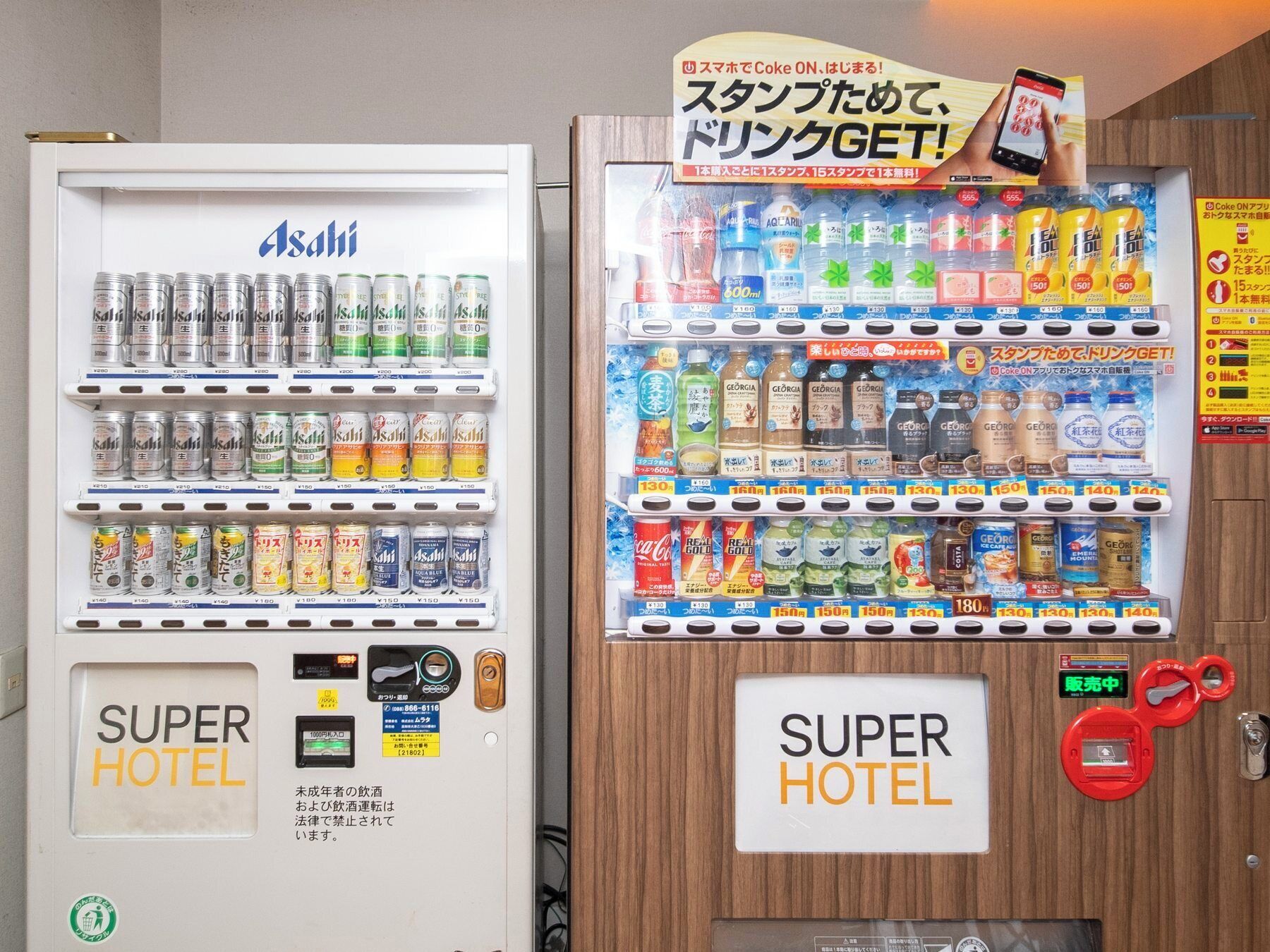 Vending machines labeled "SUPER HOTEL" with various beverages and snacks.