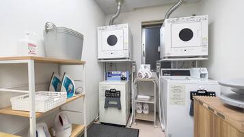 A laundry facility with multiple washing machines, a dryer, and various laundry supplies.