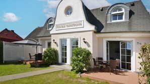 Kaksikerroksinen talo, jonka sisäänkäynnin yläpuolella on kyltti, jossa lukee: »Haus Usedom».