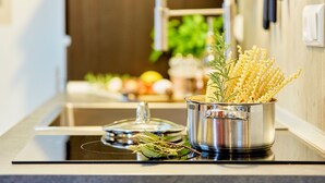 Una olla de acero inoxidable con pasta sobre una encimera de cocina.