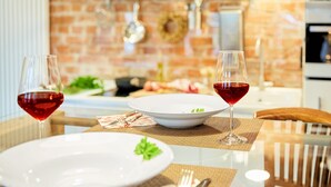 Una mesa de comedor con dos copas de vino, un plato blanco y un cuenco de ensalada.