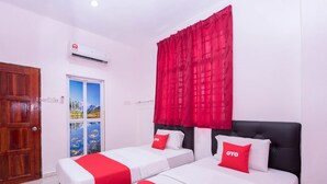 A hotel room with two beds, red and white bedding, a large window with a mountain view, and an air conditioning unit on the wall. - Hotel O Rg Motel (Changlun)
