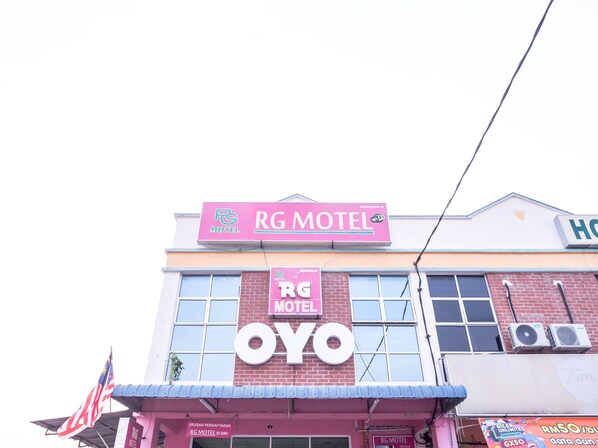 Un edificio con un cartel llamativo que dice 'RG Motel' y un cartel grande que dice 'OYO'.