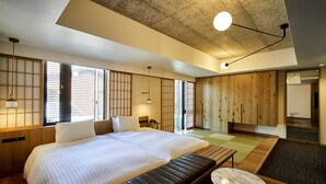 Une chambre d’hôtel moderne avec un grand lit, des éléments décoratifs en bois et une vue sur l’extérieur.