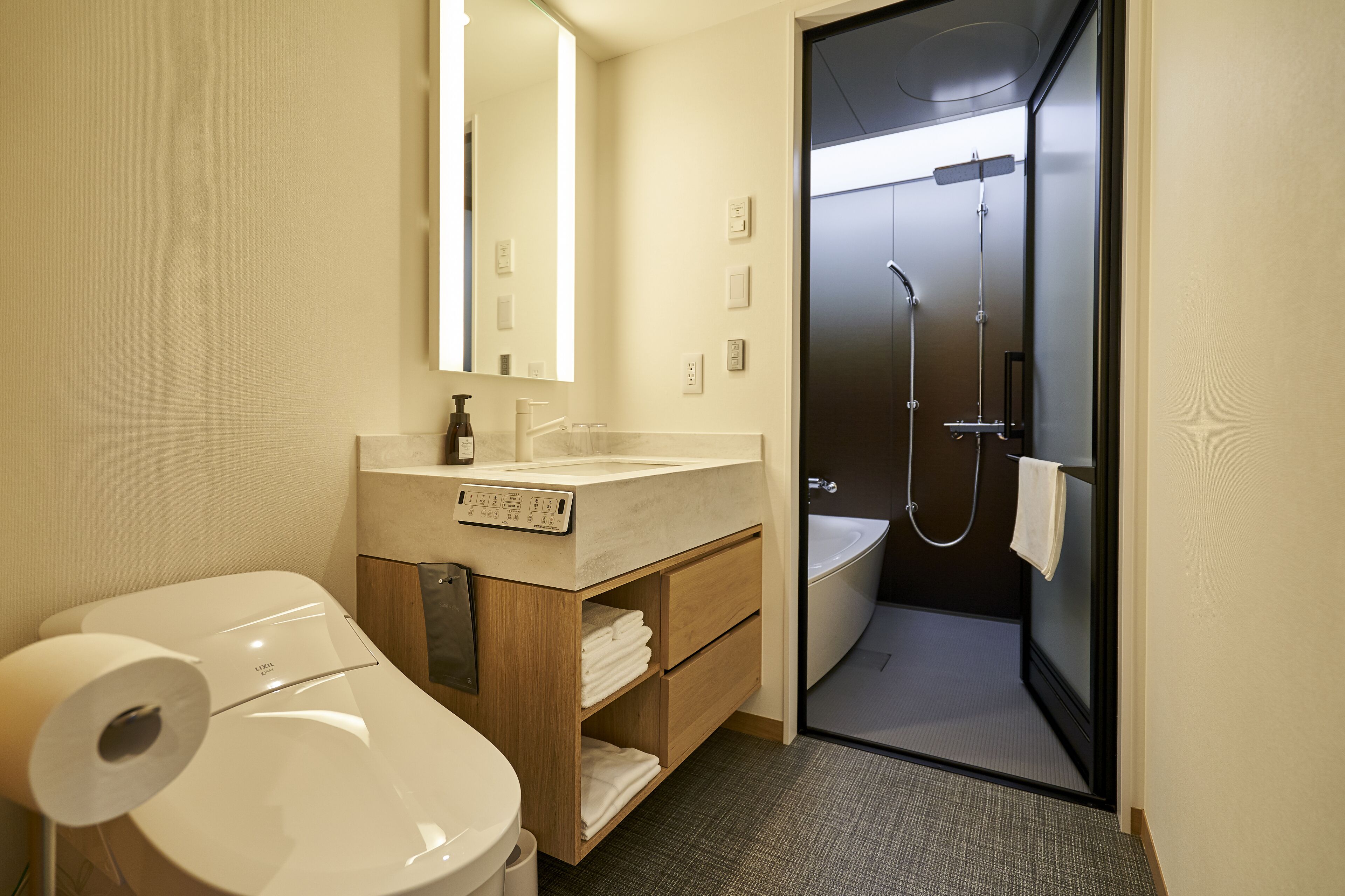 Ein modernes Badezimmer mit Toilette, Waschbecken, Spiegel und Dusche.