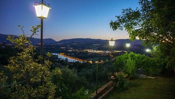 A nighttime view of a town with illuminated streets and hills in the background. - Agriturismo Pascucci (Tolentino)