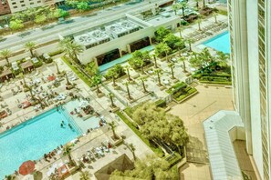 Ilmakuva hotellista, jossa on uima-allas, ulkotila istumiseen ja palmuja.