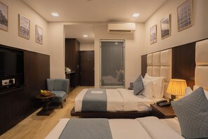 A hotel room with a bed, bedside tables, a television, and framed pictures on the walls. - The Raas Mahal (Jaipur)