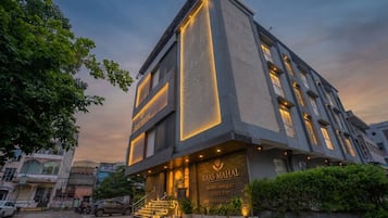 A hotel with a modern design, featuring a prominent entrance with steps and a signboard.