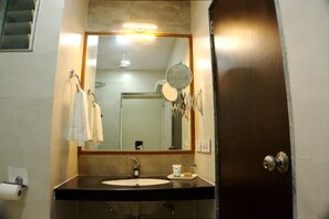Ein Badezimmer mit Waschbecken, Spiegel und Handtuchhalter.
