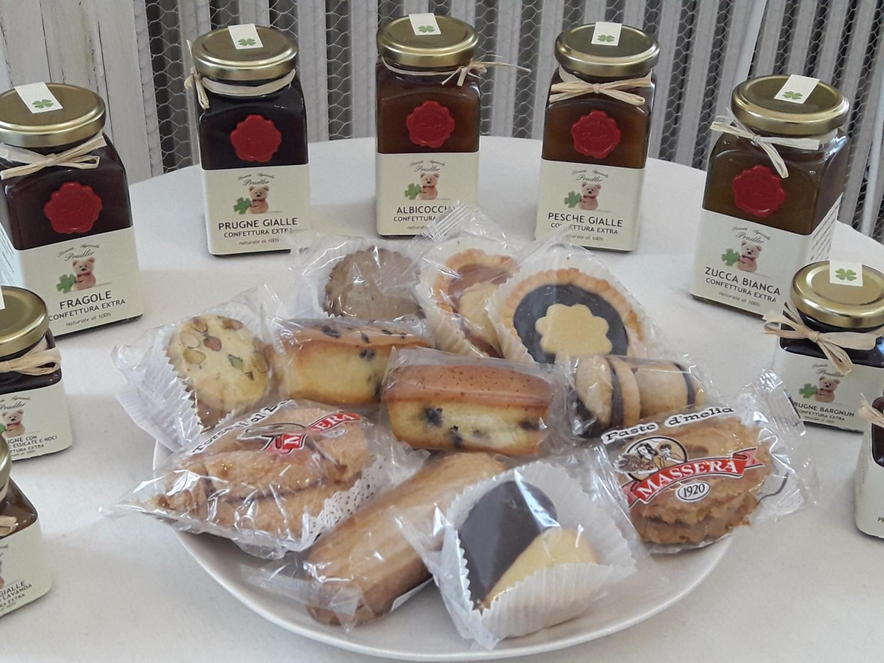 A table with various packaged food items and jars of preserves.