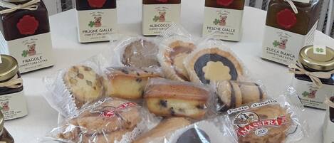 A table with various packaged food items and jars of preserves.