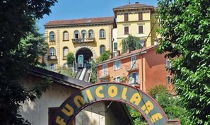 Un edificio con fachada amarilla y una gran entrada en arco que dice "FUNICOLARE".
