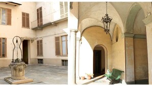 Une cour avec une fontaine, un banc et une arche.