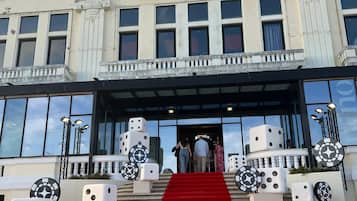Un edificio con un letrero que dice 'CASINO', alfombra roja y esculturas de dados.
