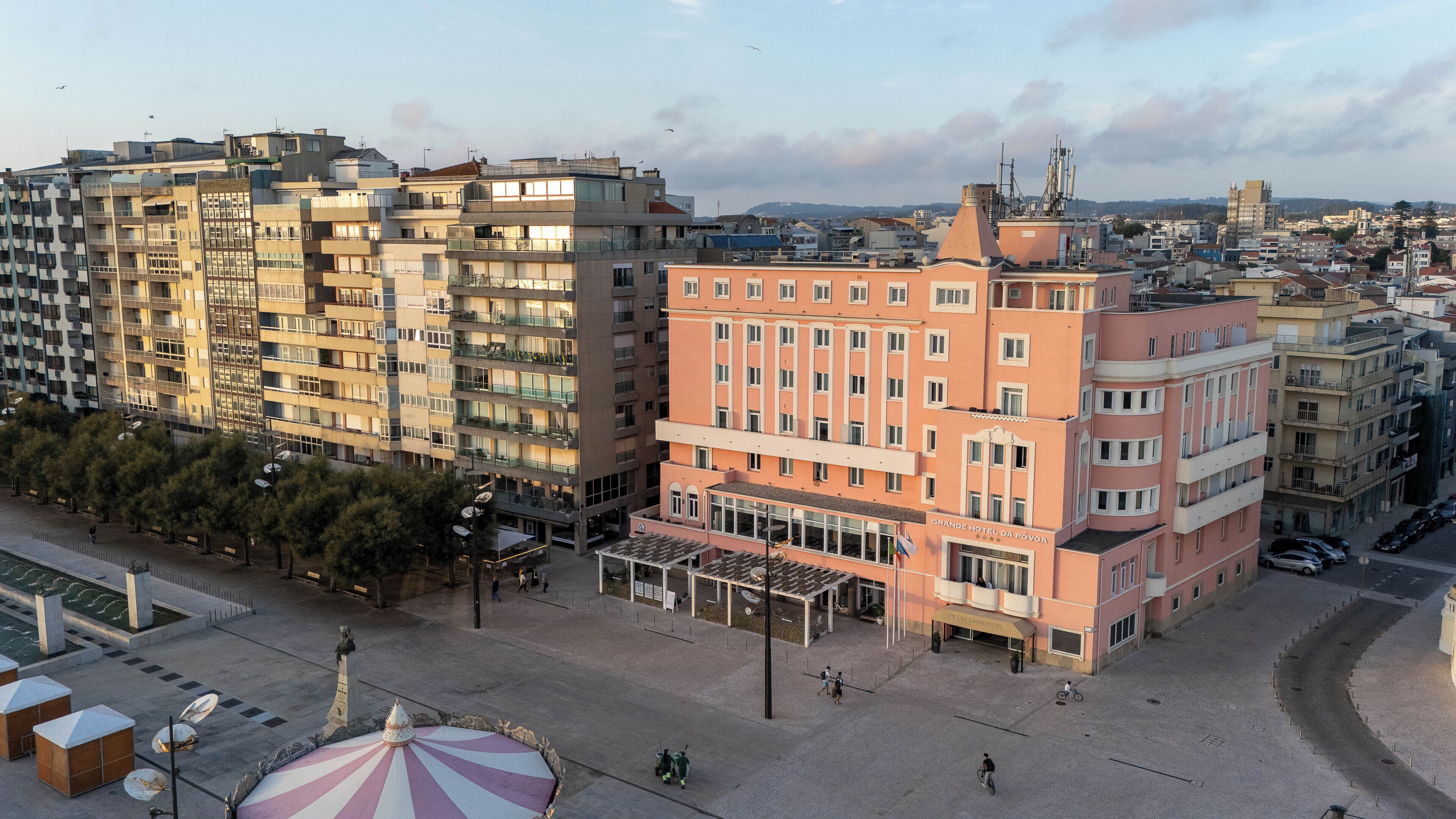 A hotel with multiple floors, a central courtyard, and a view of the surrounding cityscape.