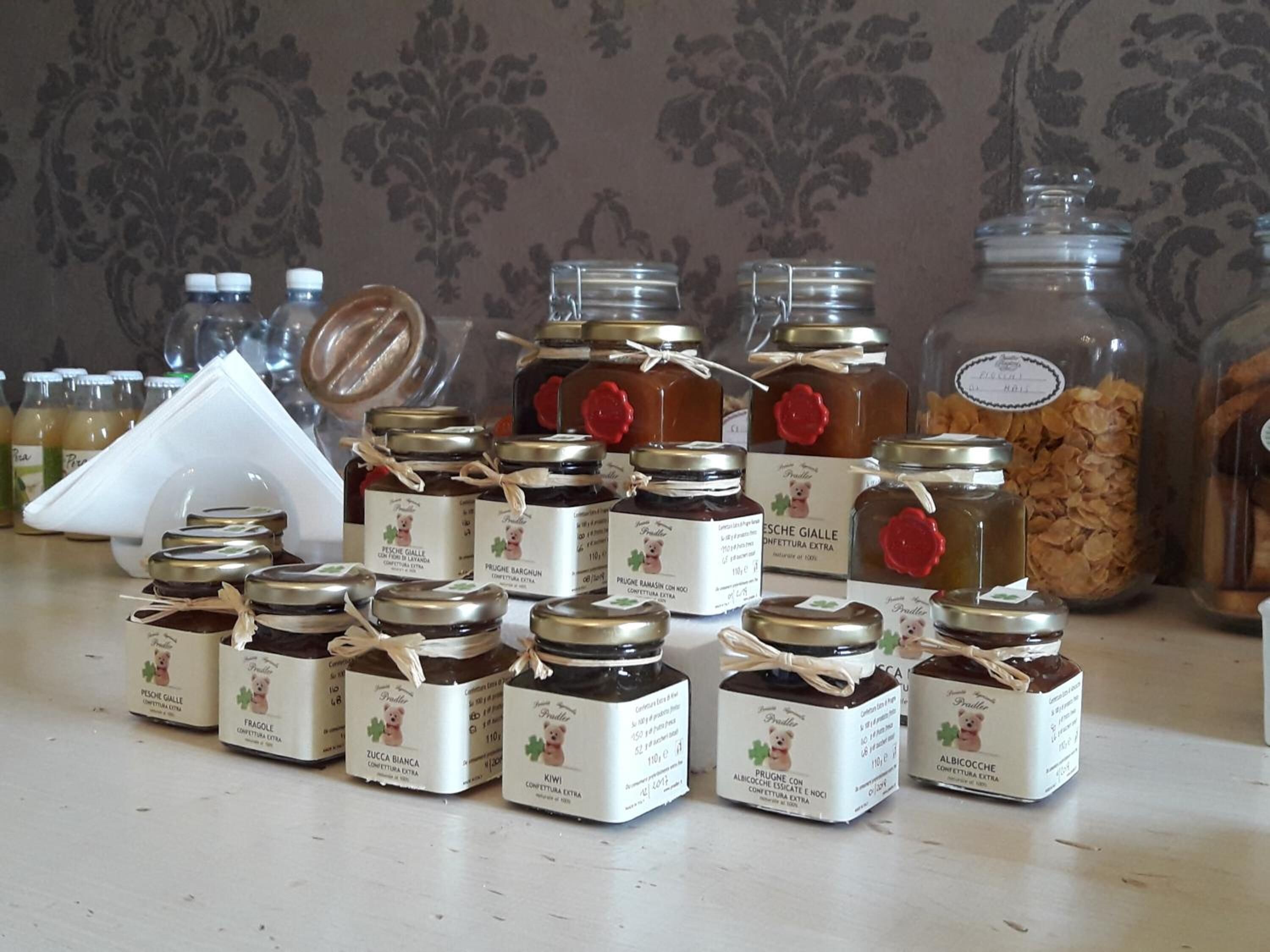 A variety of food items, including jars of preserves and bottles of liquids, displayed on a table.