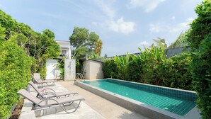 A swimming pool with lounge chairs, surrounded by greenery and a building in the background. - Malinee Resort (Choeng Thale)