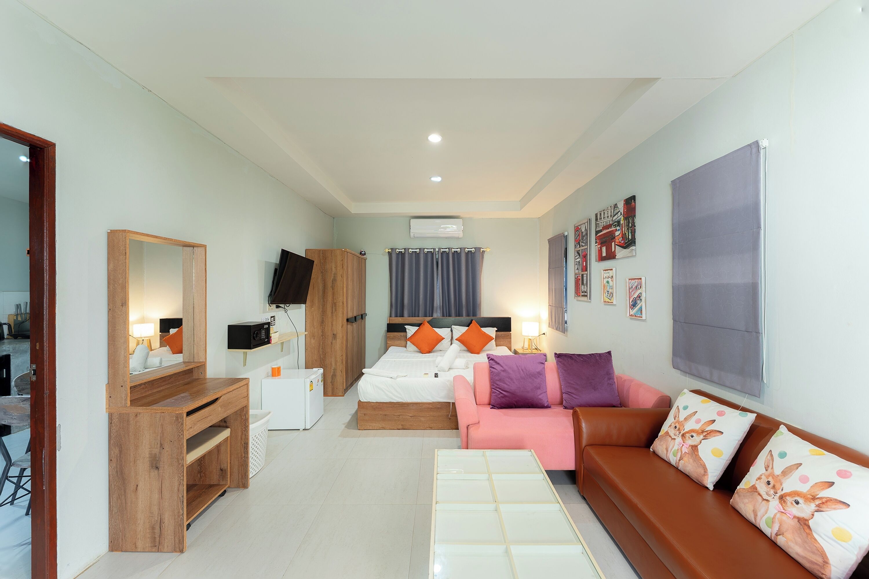 Une chambre à coucher moderne avec un lit, un canapé, un bureau et une télévision.