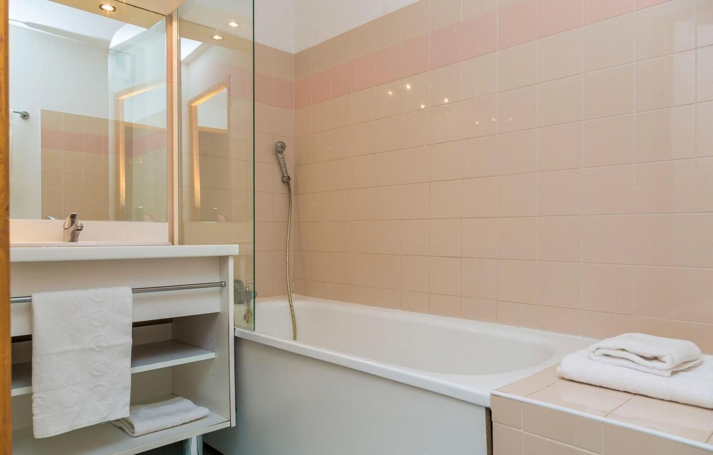 A bathroom with a glass shower enclosure, a white sink, and a bathtub.