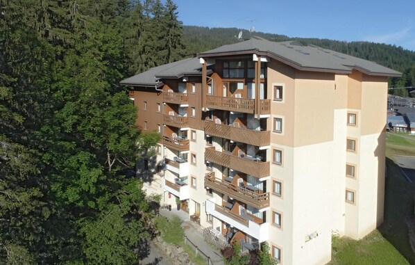 A multi-story hotel with balconies, a flat roof, and a view of surrounding greenery. - Wifi, 50m from ski slopes, balcony, tv, ski locker, 31-37m², Morillon (Morillon)