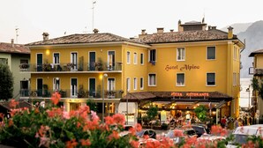 Ein gelbes Gebäude mit Balkonen und einem Restaurant namens "Pizza Ristorante" im Erdgeschoss.