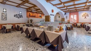 Ein Restaurant mit hoher Decke, freiliegenden Balken und einer zentralen Buffettheke.